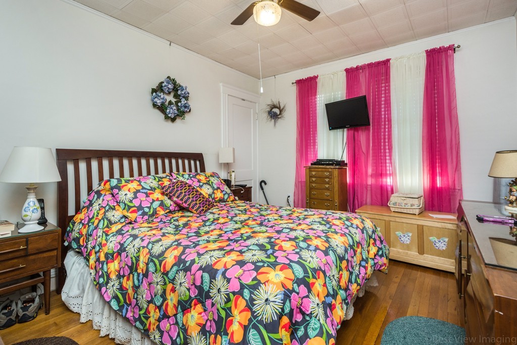 59-61 Brington Road Brookline, MA 02445 - Photo 11 of 19 a bedroom with a bed and a chandelier