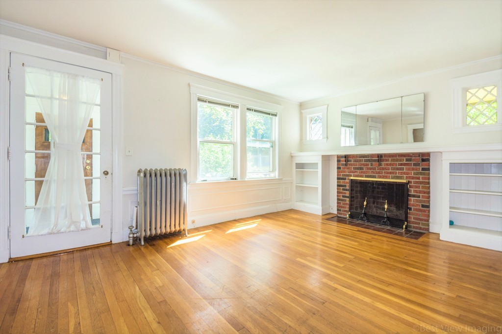 59-61 Brington Road Brookline, MA 02445 - Photo 12 of 19 a view of a livingroom with a fireplace wooden floor and window