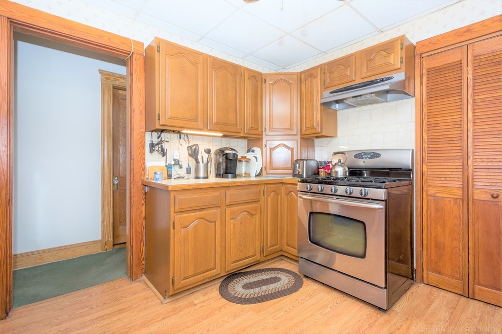 59-61 Brington Road Brookline, MA 02445 - Photo 7 of 19 a kitchen with stainless steel appliances granite countertop a stove a sink and a microwave