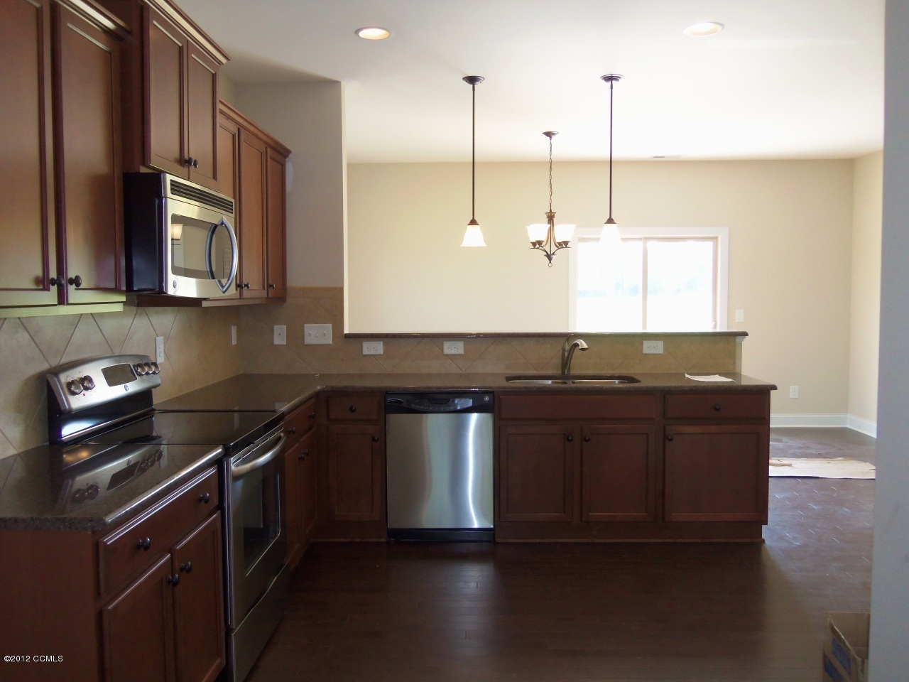 103 Summer Rst Trail Hubert, NC 28539 - Photo 5 of 13 Kitchen features stainless steel appliances, engineered hardwood floors, tile backsplash, recessed lighting and pendant lights over breakfast bar.