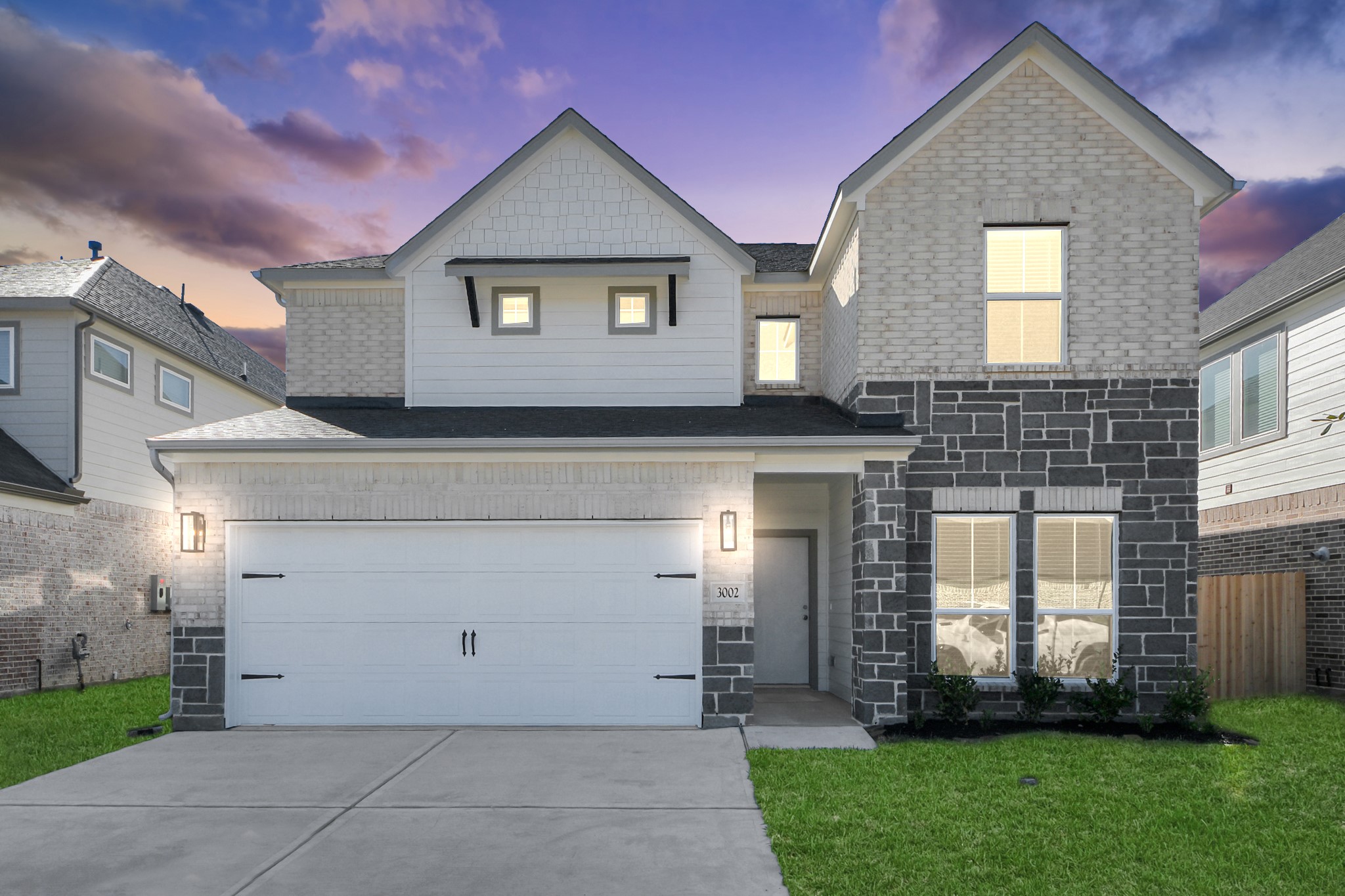 a front view of a house with a garden and plants
