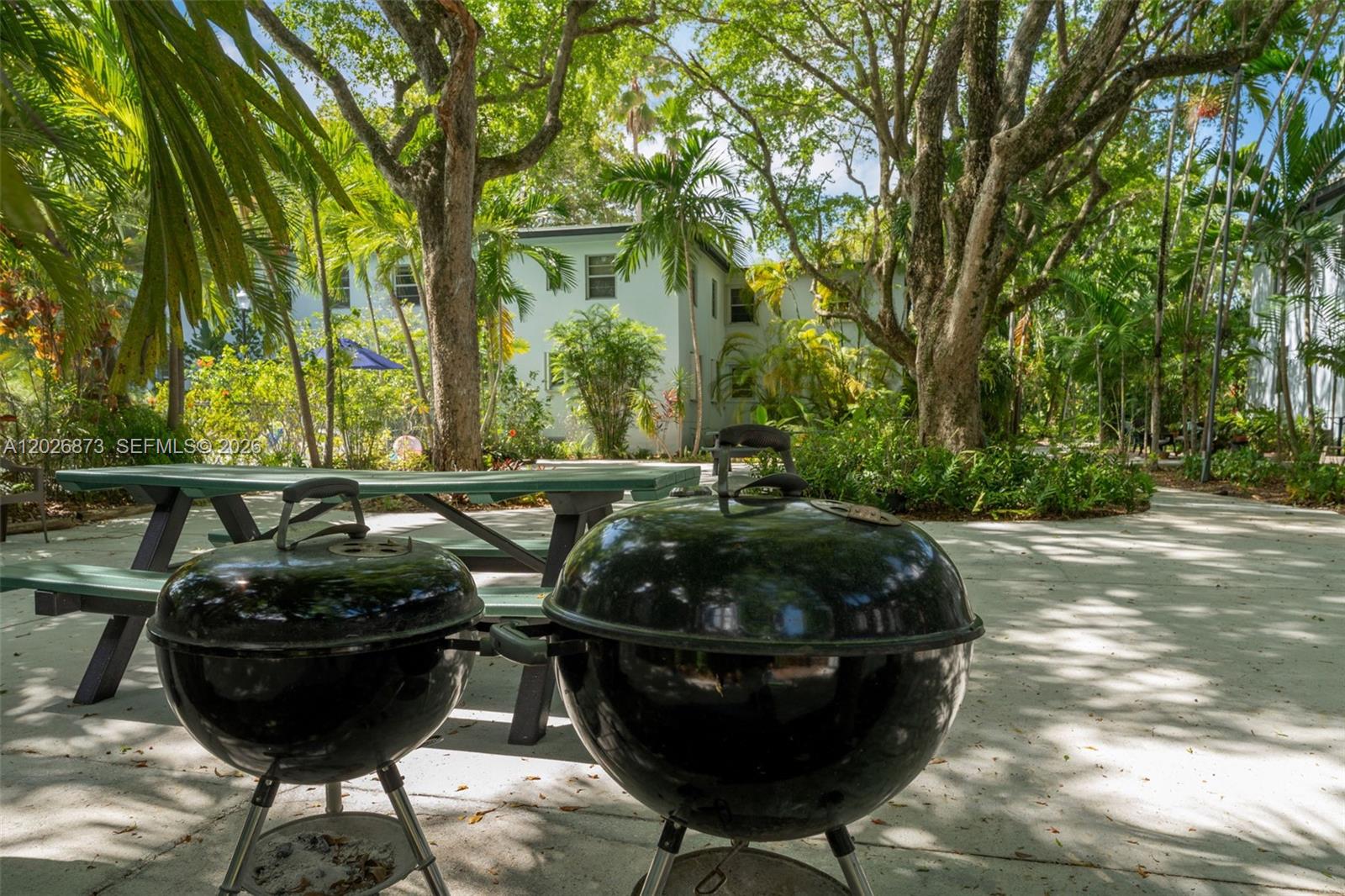 5590 Southwest 78th Street, Unit 133B Miami, FL 33143 - Photo 13 of 18 a couple of potted plants sitting in middle of a yard
