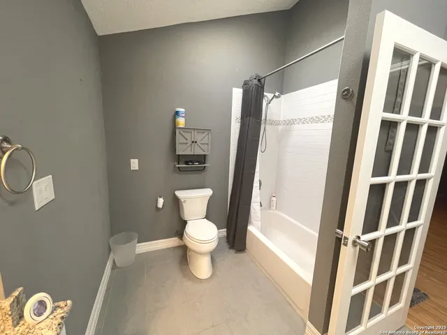 a white toilet sitting next to a bathroom sink and a shower