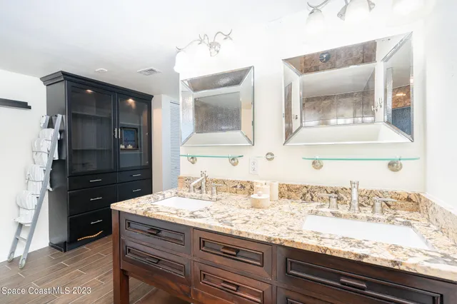 a bathroom with a granite countertop sink a toilet and a mirror