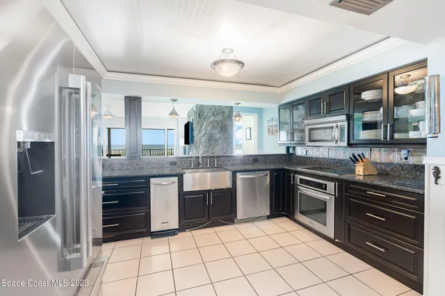 a kitchen with stainless steel appliances granite countertop a refrigerator and a stove top oven