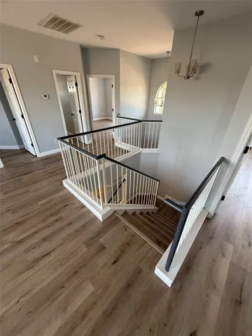 a view of staircase with wooden floor and fan