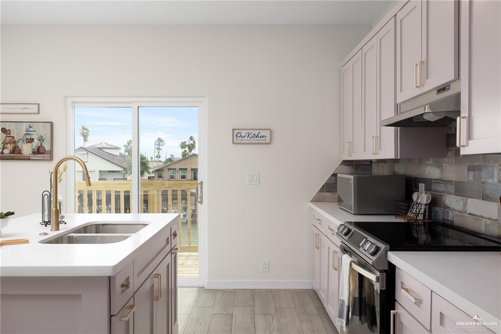 1009 Bass Avenue, Unit 3 Port Isabel, TX 78578 - Photo 6 of 14 a kitchen with stainless steel appliances a sink stove and cabinets