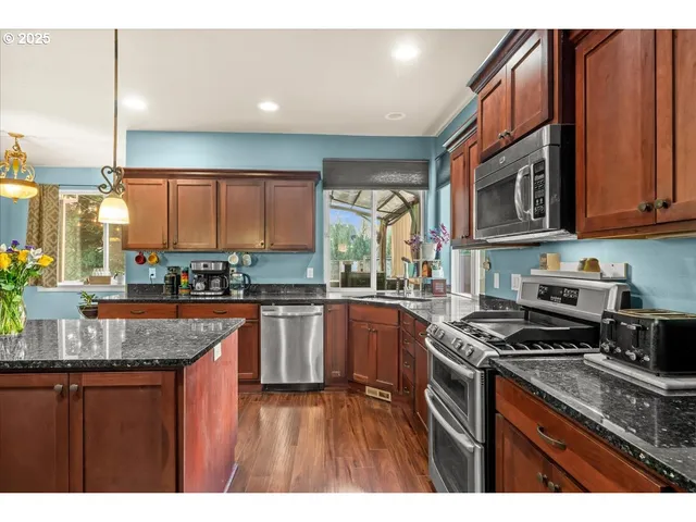 a kitchen with stainless steel appliances granite countertop a stove microwave and refrigerator