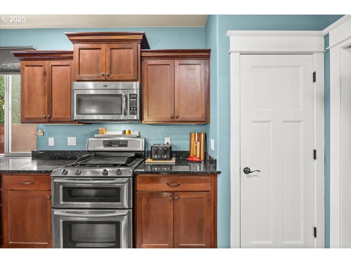 1138 37th Avenue Forest Grove, OR 97116 - Photo 19 of 48 a kitchen with stainless steel appliances granite countertop a stove microwave and refrigerator