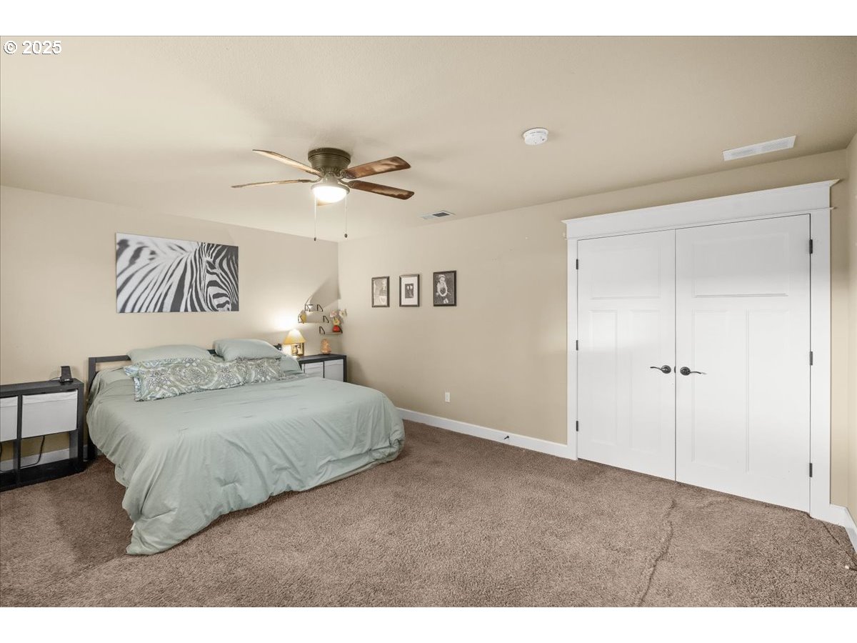 1138 37th Avenue Forest Grove, OR 97116 - Photo 28 of 48 a bedroom with a bed and a chandelier