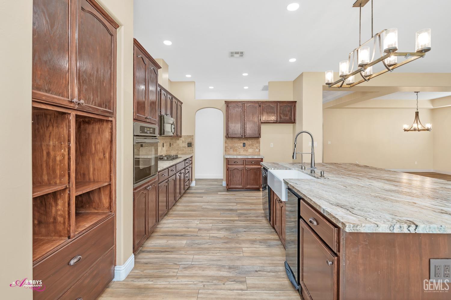 Undisclosed Address Bakersfield, CA 93311 - Photo 16 of 41 a kitchen with kitchen island granite countertop a large counter top space appliances and cabinets