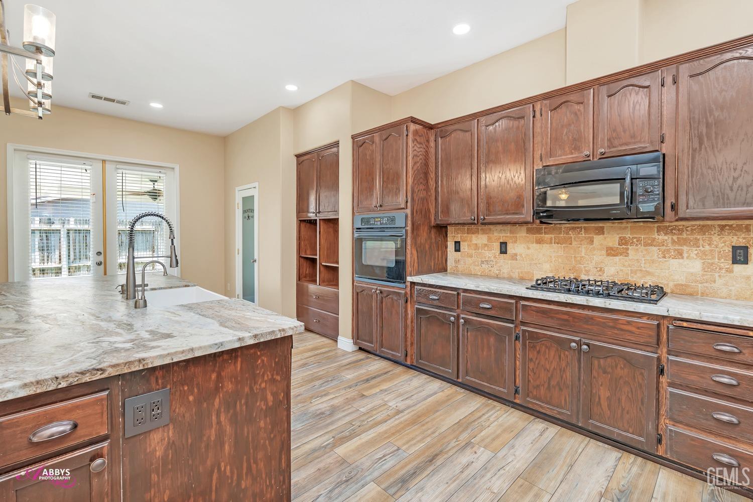 Undisclosed Address Bakersfield, CA 93311 - Photo 19 of 41 a kitchen with stainless steel appliances wooden cabinets a stove top oven a sink and dishwasher