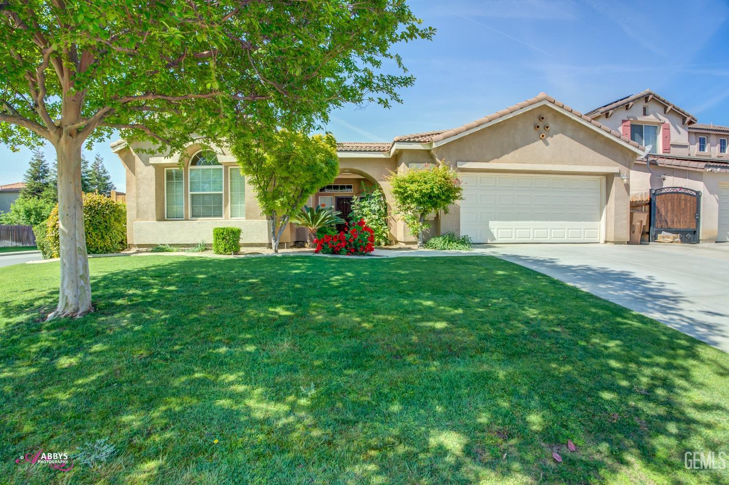 Undisclosed Address Bakersfield, CA 93311 - Photo 2 of 41 a front view of a house with a yard and garage