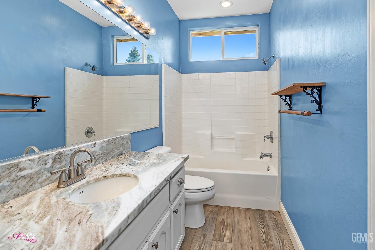 Undisclosed Address Bakersfield, CA 93311 - Photo 29 of 41 a bathroom with a granite countertop sink a toilet and shower