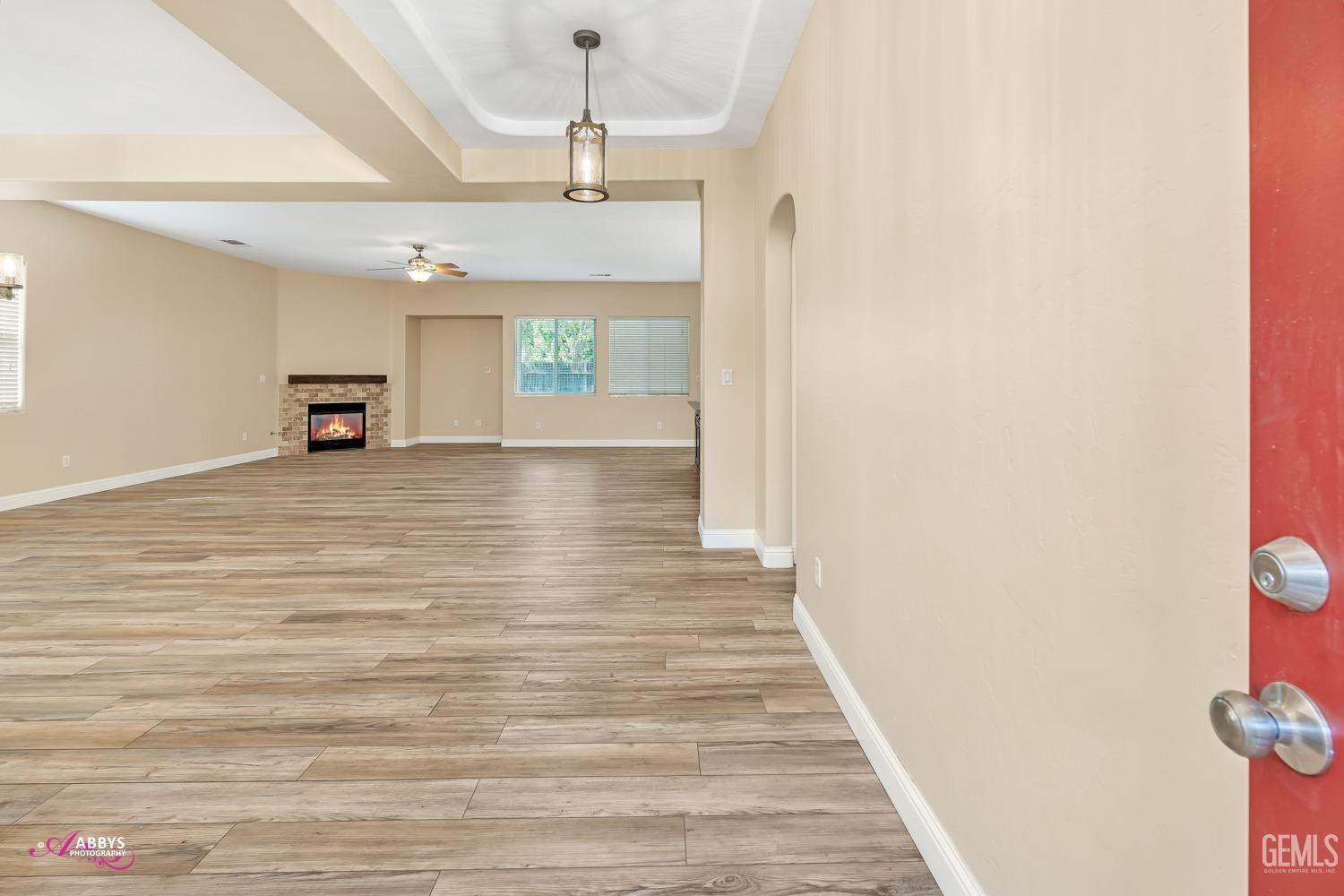 Undisclosed Address Bakersfield, CA 93311 - Photo 9 of 41 a view of a hallway with wooden floor and chandelier