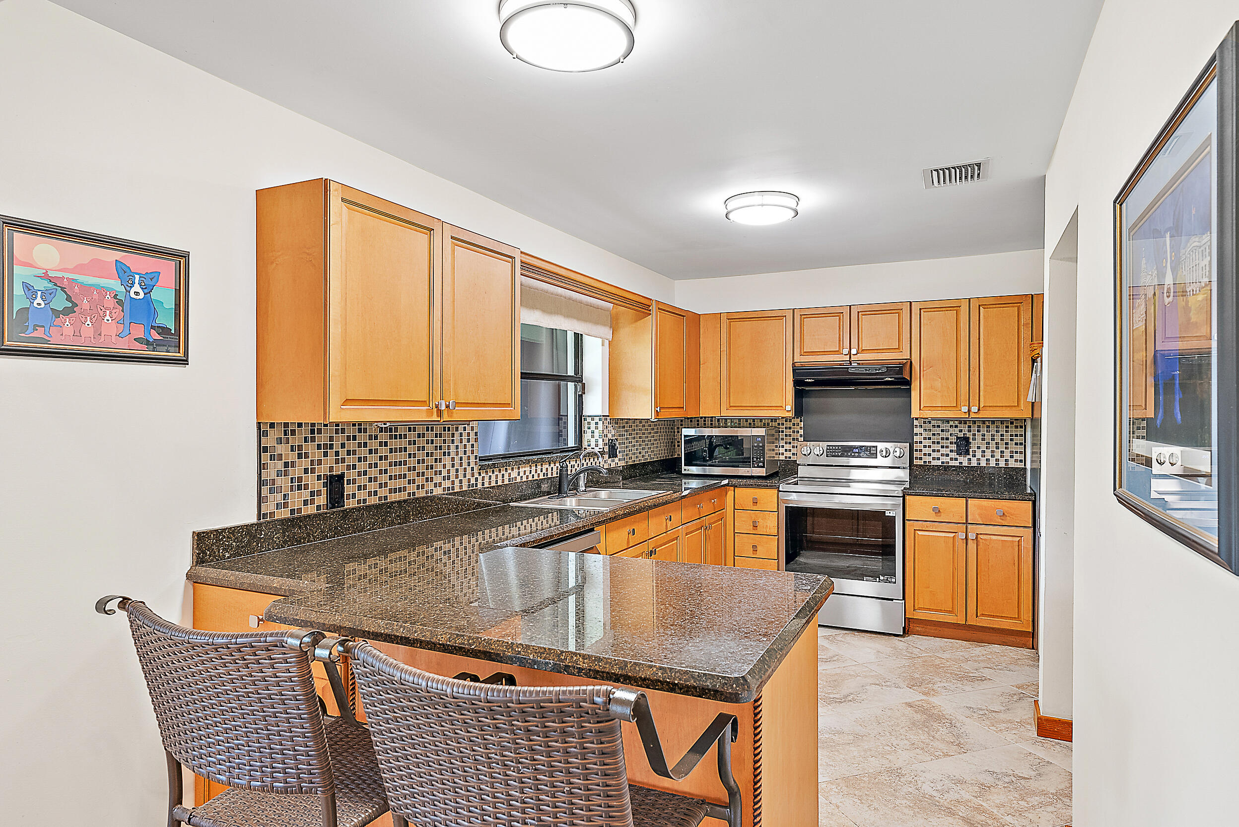 15629 95th Avenue North Jupiter, FL 33478 - Photo 10 of 25 a kitchen with stainless steel appliances granite countertop a sink counter space and a window