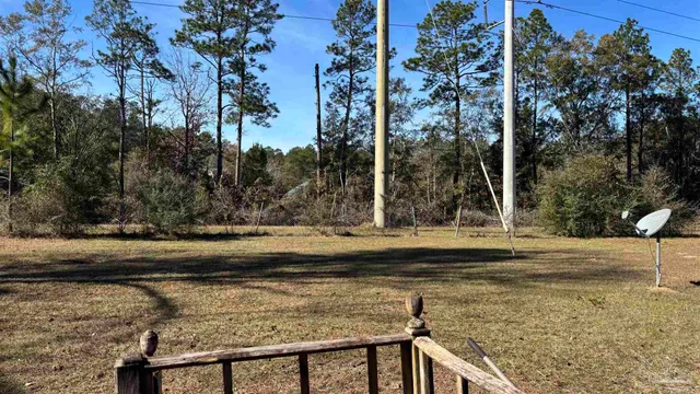 a view of a yard with wooden fence