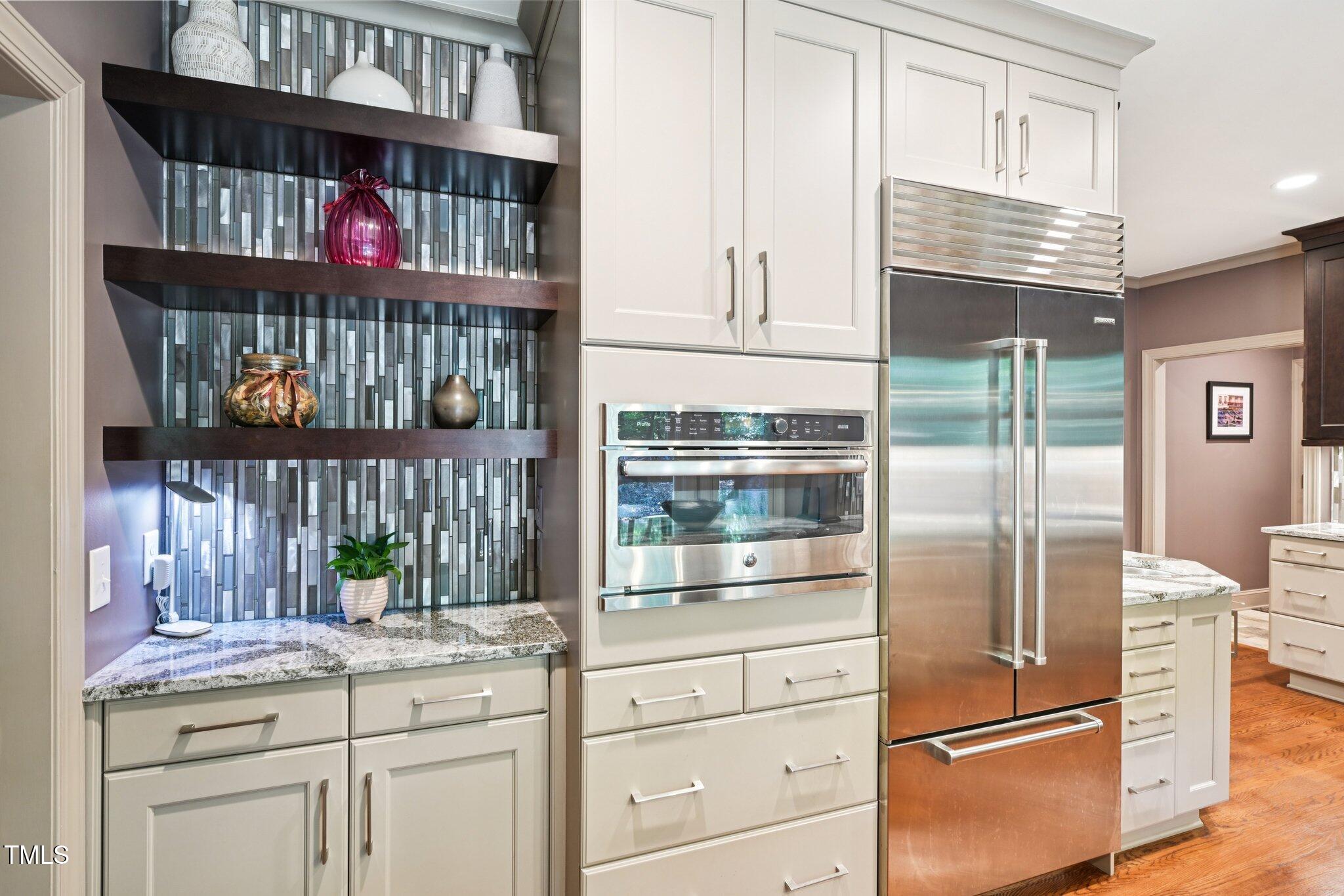3413 1st Place Raleigh, NC 27613 - Photo 14 of 43 a kitchen with granite countertop a refrigerator and cabinets