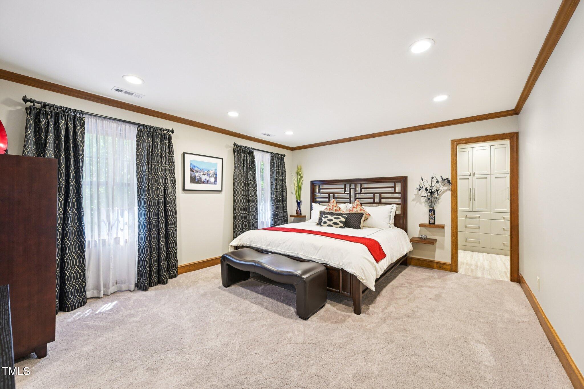 3413 1st Place Raleigh, NC 27613 - Photo 24 of 43 a spacious bedroom with a large bed and a chandelier