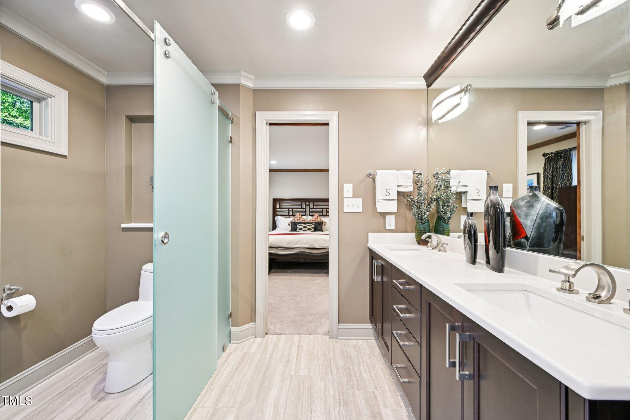 3413 1st Place Raleigh, NC 27613 - Photo 30 of 43 a en suite bathroom with a double vanity sink a mirror and a toilet