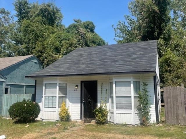 View of front of property featuring covered porch, a shingled roof, and an outdoor structure