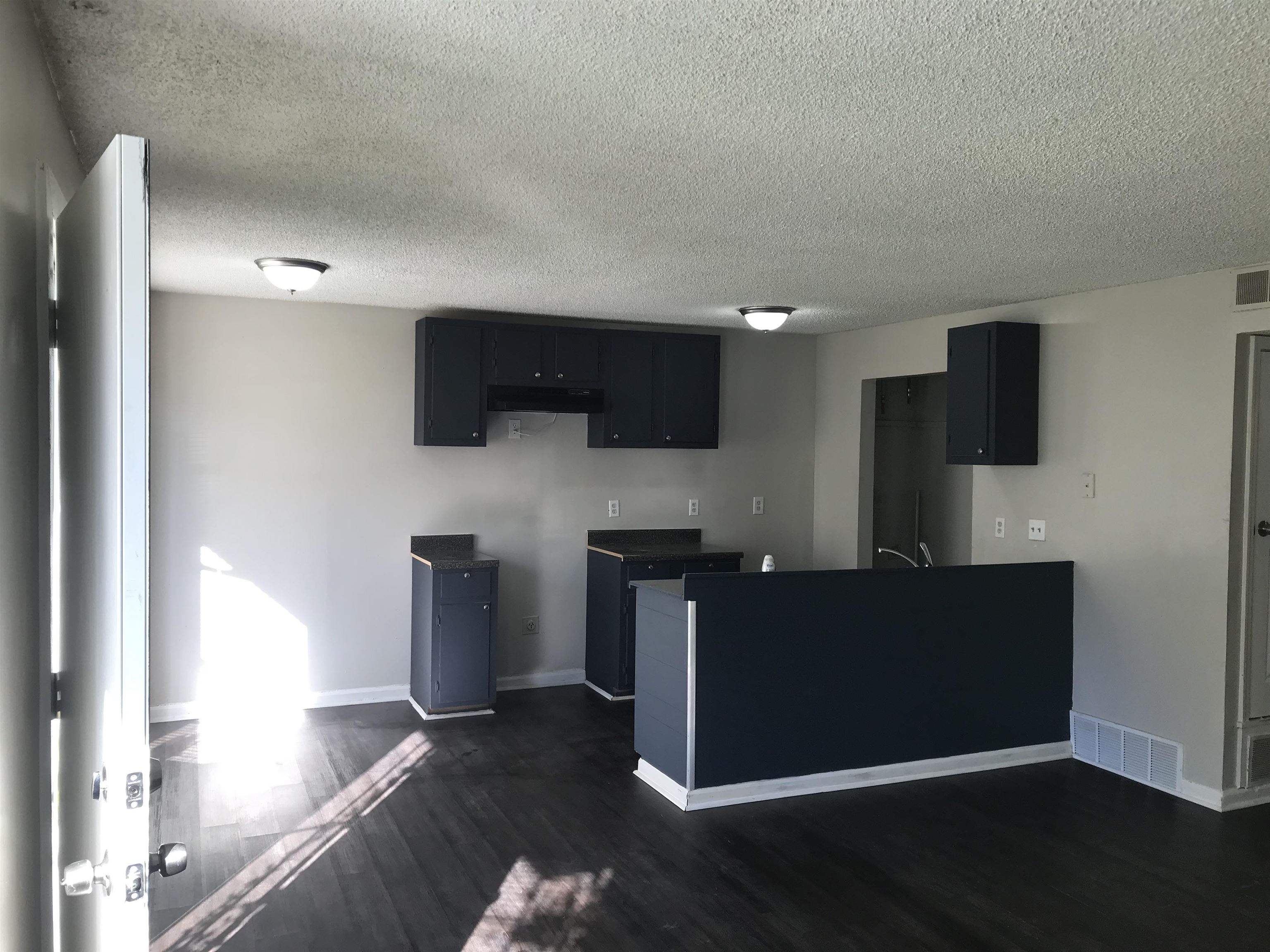 48 South Bristol Road Marion, AR 72364 - Photo 11 of 18 Kitchen featuring dark wood-style flooring, a peninsula, a textured ceiling, dark cabinetry, and dark countertops