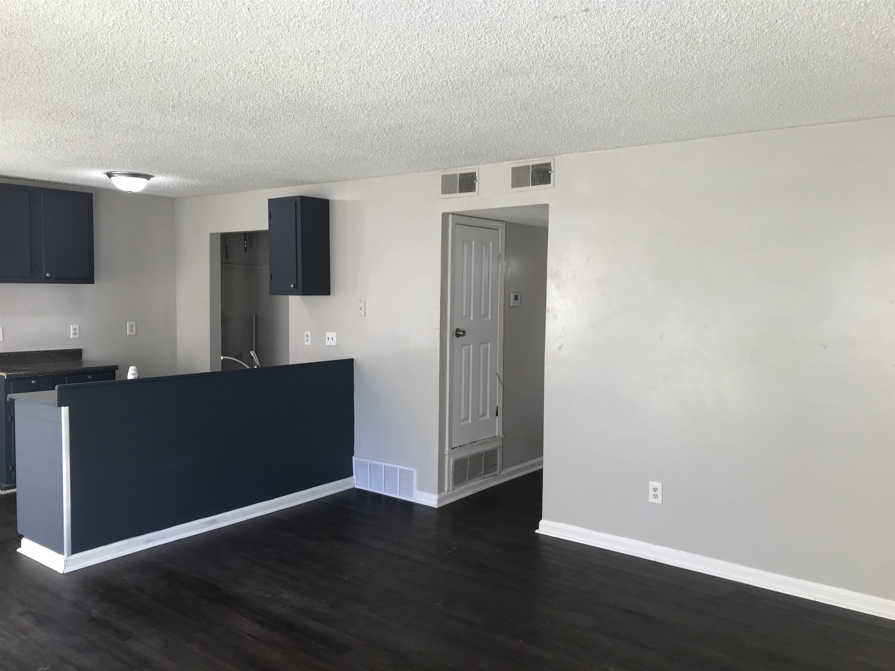 48 South Bristol Road Marion, AR 72364 - Photo 10 of 18 Kitchen with dark wood-style floors, dark countertops, a textured ceiling, a peninsula, and dark cabinetry