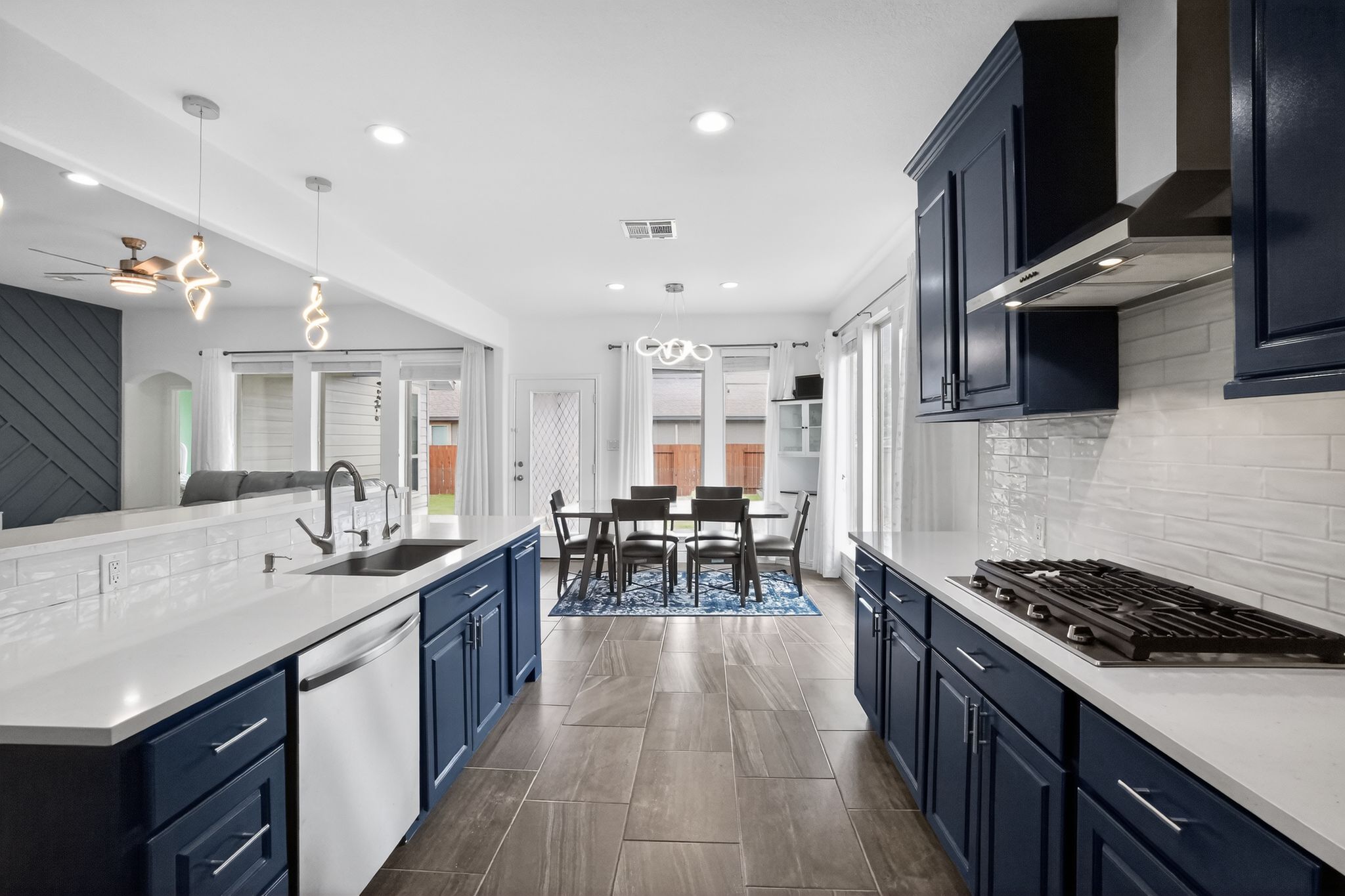 400 Cortona Lane Georgetown, TX 78628 - Photo 16 of 40 Kitchen with stainless steel appliances, decorative light fixtures, blue cabinets, arched walkways, and backsplash