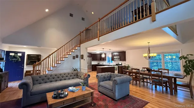 a living room with furniture kitchen view and a wooden floor