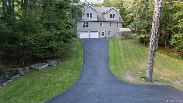 a view of a house with a big yard plants and large trees