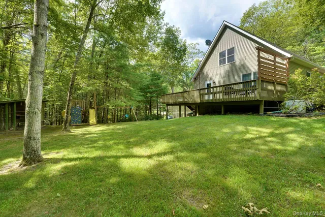 a view of a house with backyard and a tree
