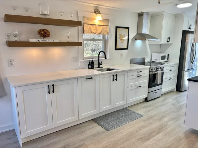 a kitchen with stainless steel appliances a stove a sink and a refrigerator