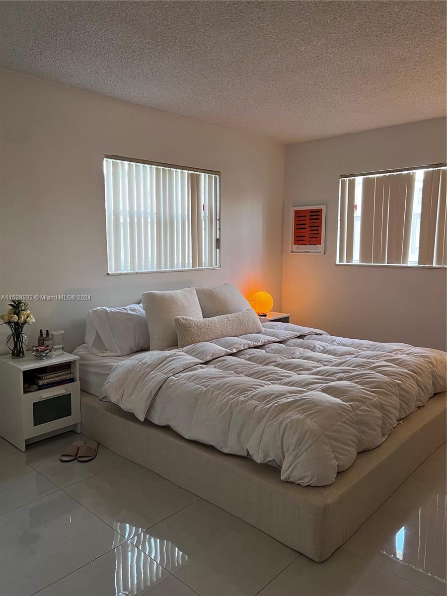 8794 Southwest 12th Street, Unit 108 Miami, FL 33174 - Photo 2 of 7 a bedroom with bed and a window