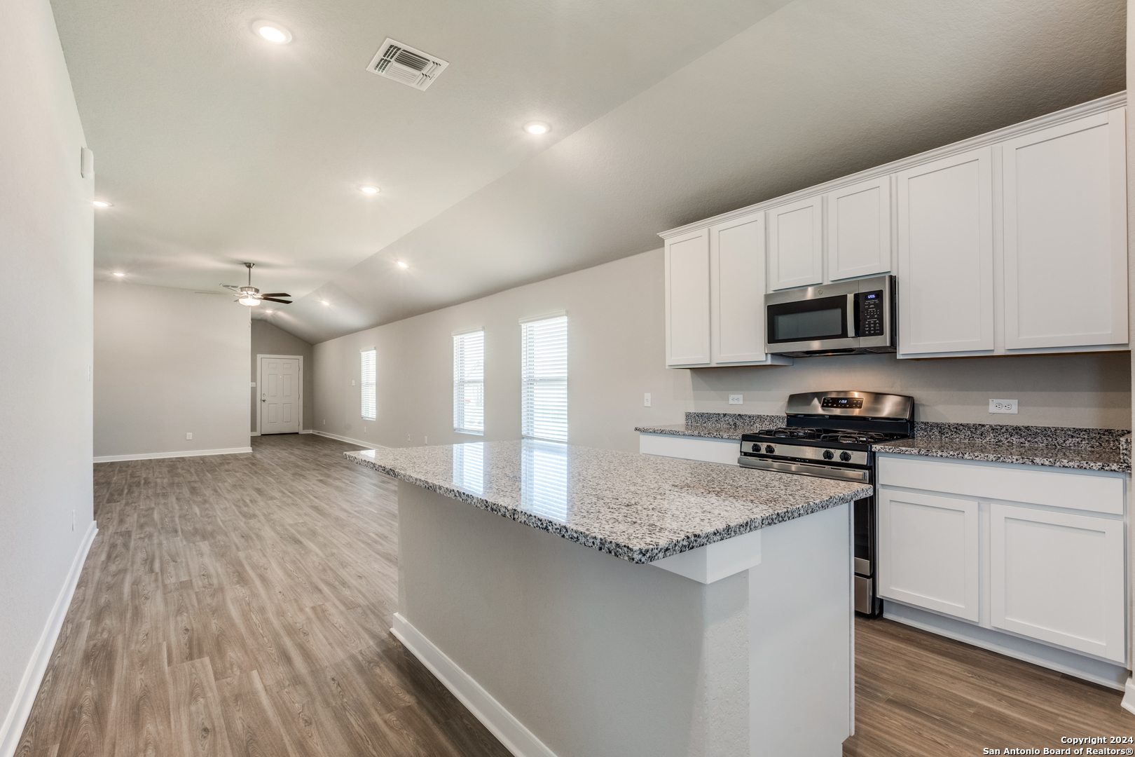 13602 Crossbow Ridge San Antonio, TX 78253 - Photo 4 of 12 a kitchen with kitchen island granite countertop a sink stove and microwave