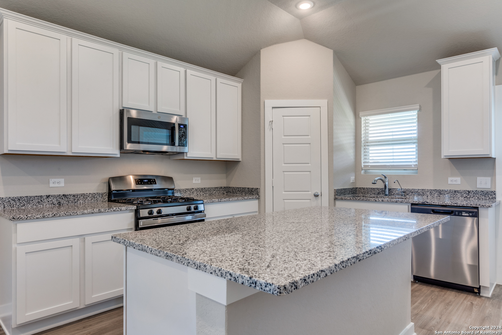 13602 Crossbow Ridge San Antonio, TX 78253 - Photo 5 of 12 a kitchen with stainless steel appliances granite countertop a sink a stove a microwave and cabinets