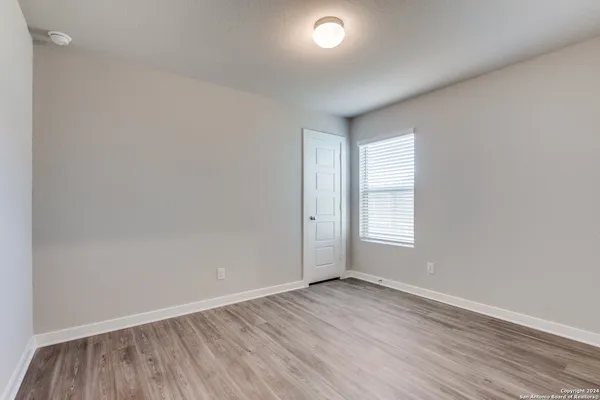 an empty room with wooden floor and window