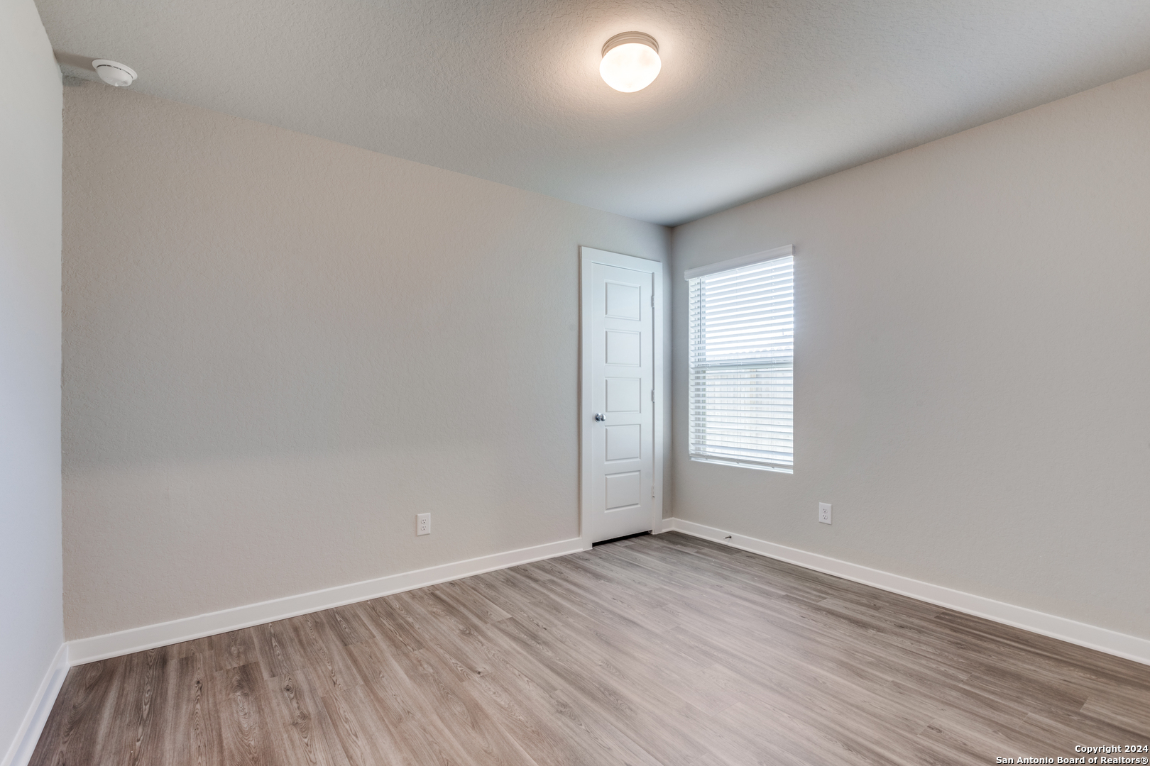 13602 Crossbow Ridge San Antonio, TX 78253 - Photo 8 of 12 an empty room with wooden floor and window