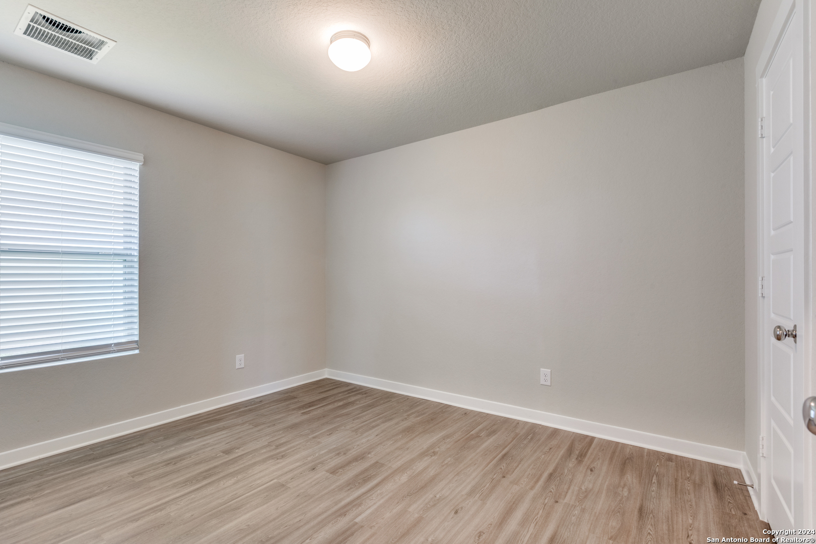 13602 Crossbow Ridge San Antonio, TX 78253 - Photo 9 of 12 an empty room with wooden floor and windows