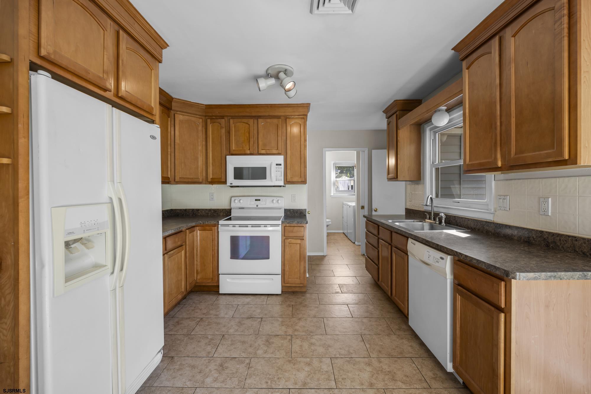 121 Osborne Road Somers Point, NJ 08244 - Photo 11 of 28 a kitchen with stainless steel appliances granite countertop a stove a sink and a refrigerator