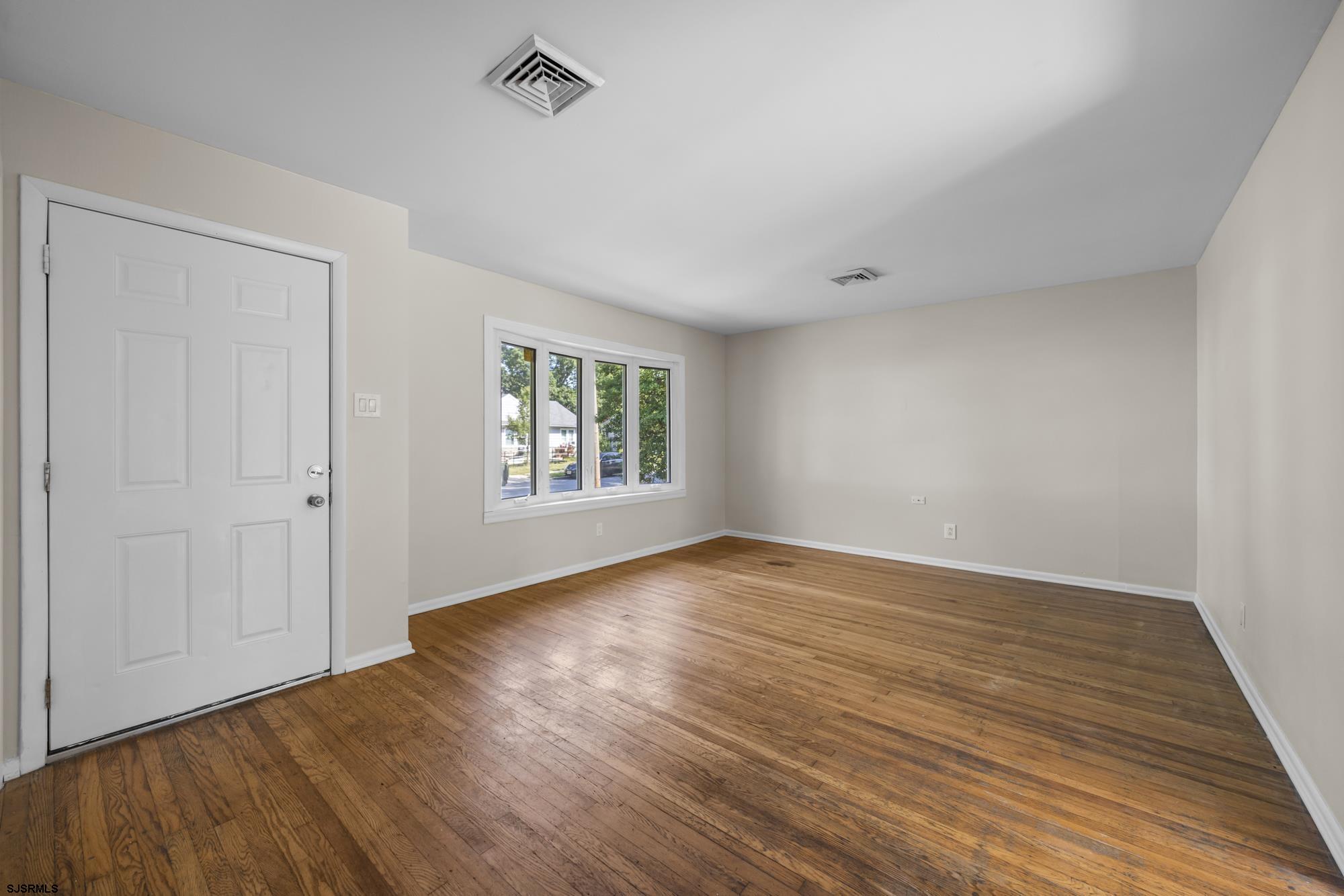 121 Osborne Road Somers Point, NJ 08244 - Photo 4 of 28 an empty room with wooden floor and windows