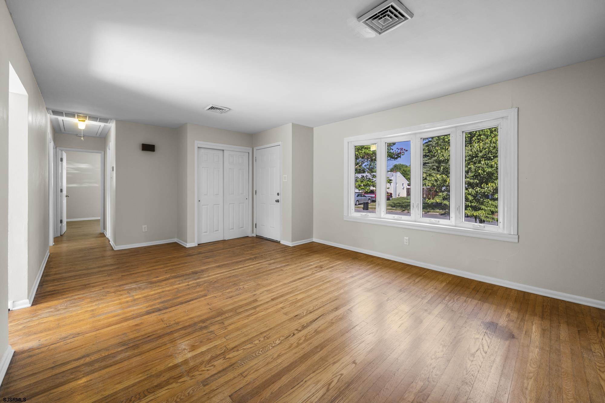 121 Osborne Road Somers Point, NJ 08244 - Photo 5 of 28 a view of an empty room with wooden floor and a window