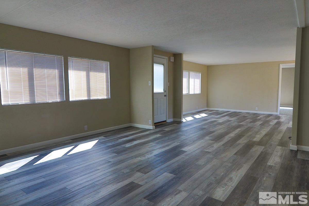 290 Zircon Drive Reno, NV 89521 - Photo 8 of 26 an empty room with wooden floor and windows