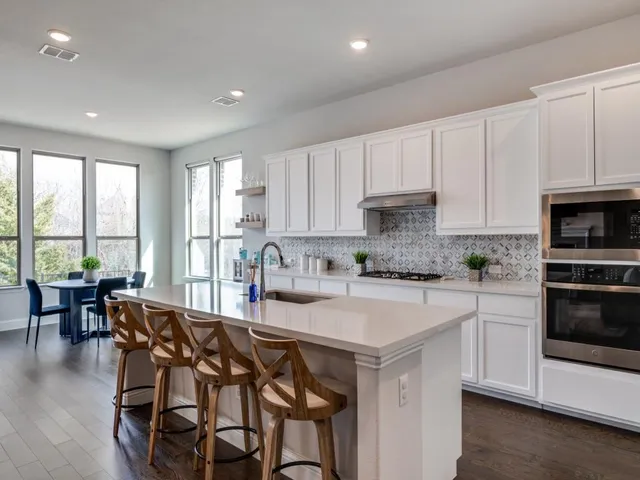 a kitchen with a table chairs stove and cabinets