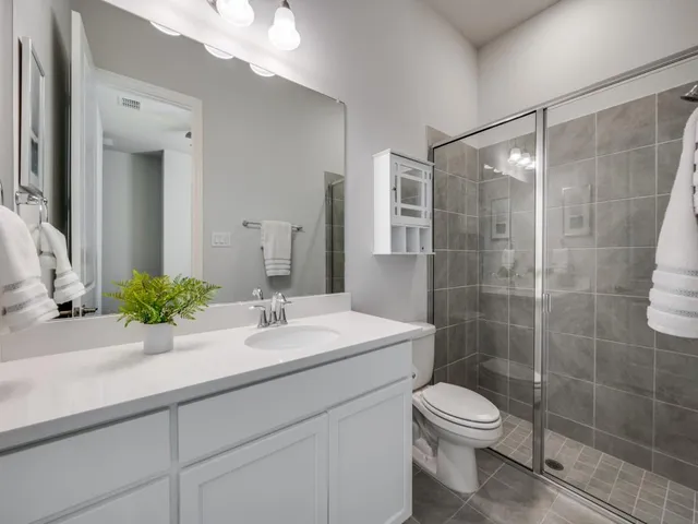 a bathroom with a sink a toilet and shower