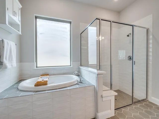 a bathroom with a tub a toilet and a shower