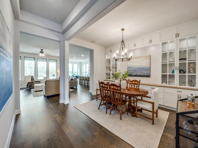 a view of a livingroom with furniture a chandelier and wooden floor