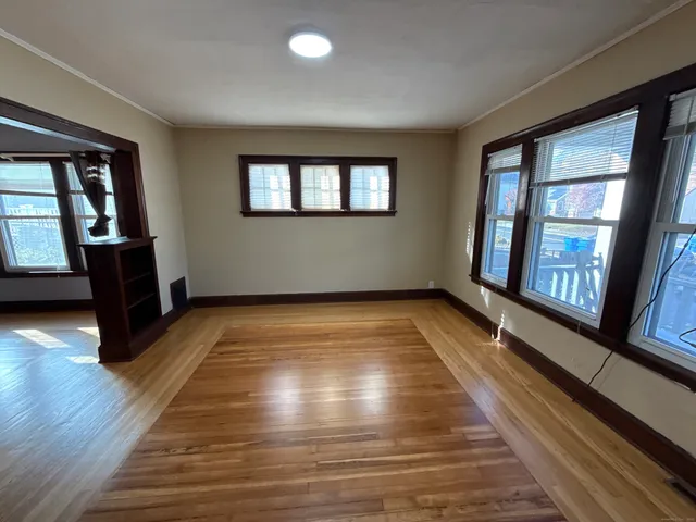 a view of an empty room with glass door and wooden floor