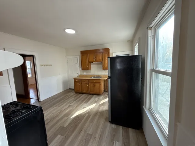a view of a kitchen with refrigerator and wooden floor