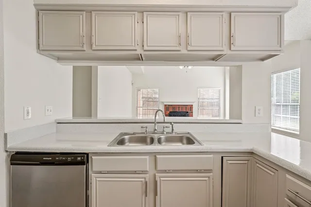 a kitchen with granite countertop white cabinets and a sink