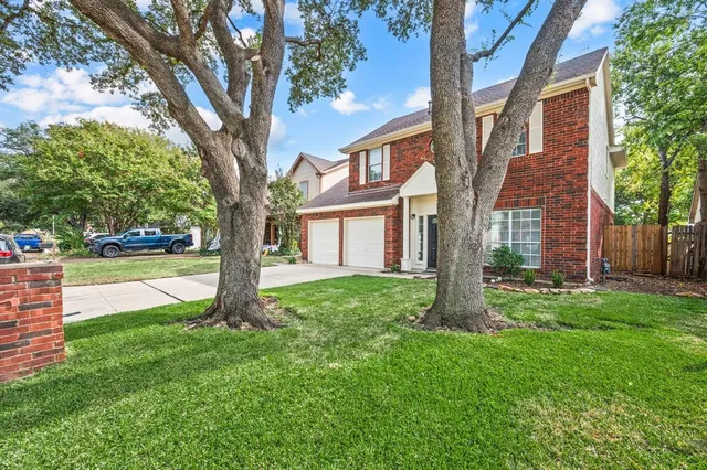 front view of a house with a yard and an trees